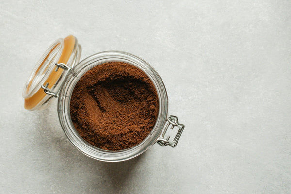 Premium cacao powder in a glass container representing bulk cacao sourcing, manufacturing-grade ingredient quality, and commercial food production