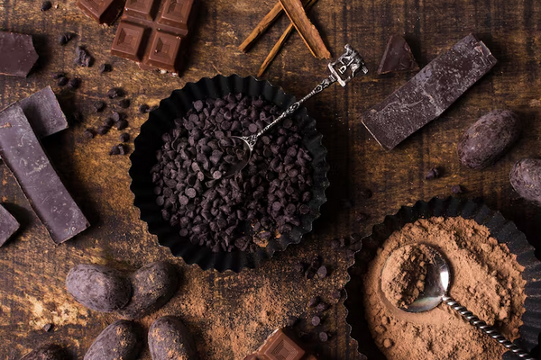 Cacao nibs, cacao powder, chocolate bars, and cacao beans displayed together, representing cacao processing and premium cacao products
