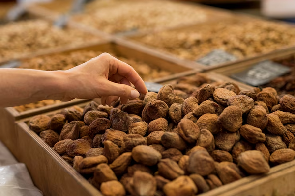 Hand selecting cacao beans from a tray, representing quality inspection and sourcing of premium cacao beans