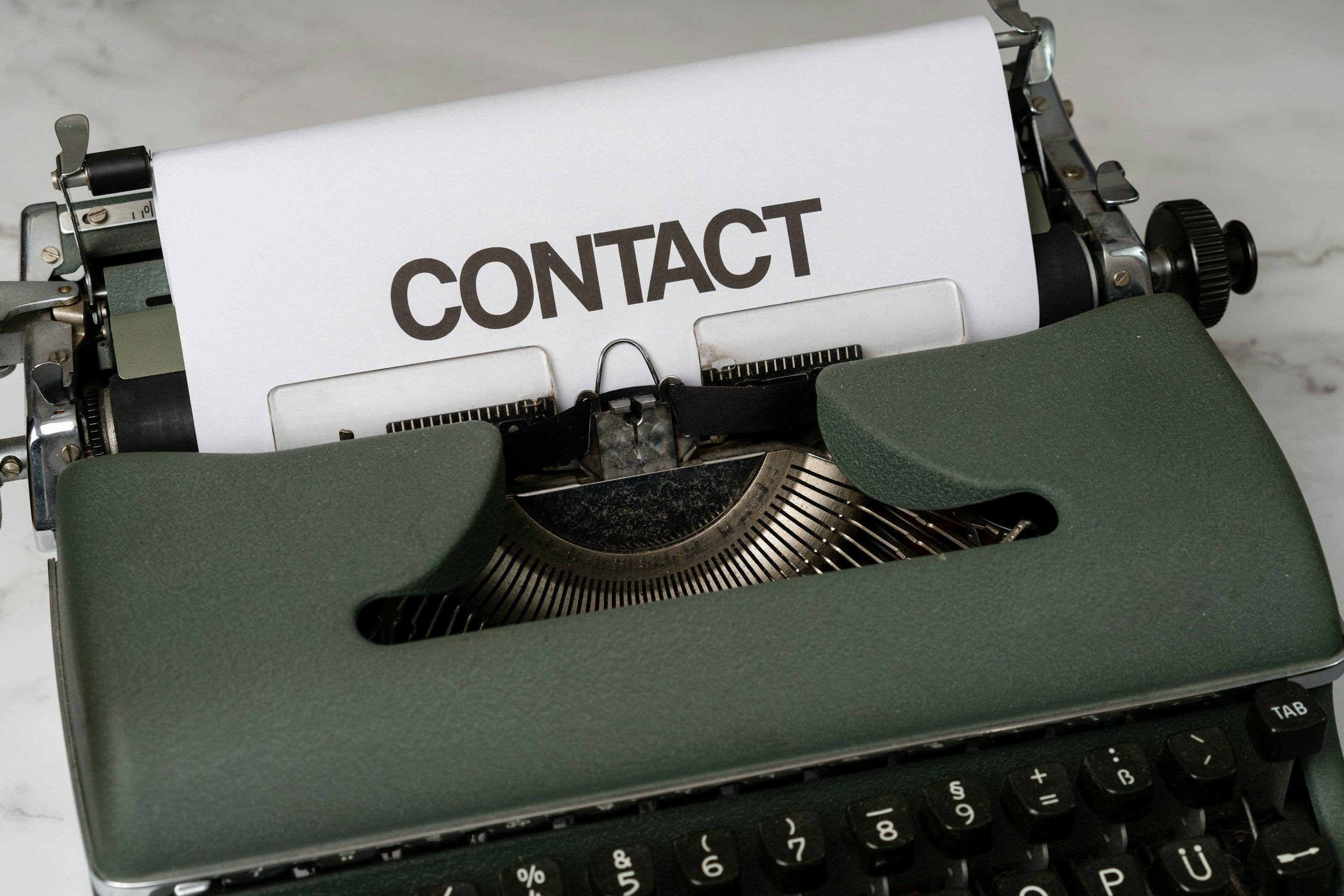 Vintage typewriter with a sheet of paper displaying the word 'CONTACT'.